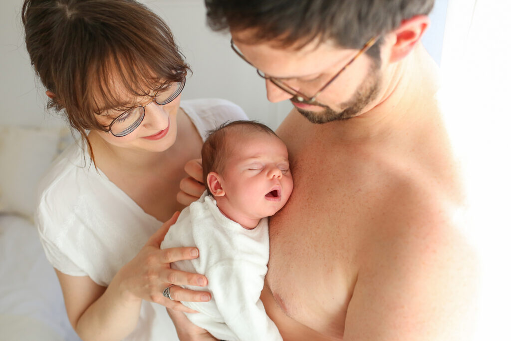 nouveau né dans les bras de ses parents