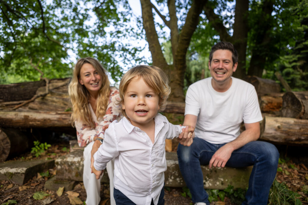 Famille réunie dans un parc arboré pour une séance engagement